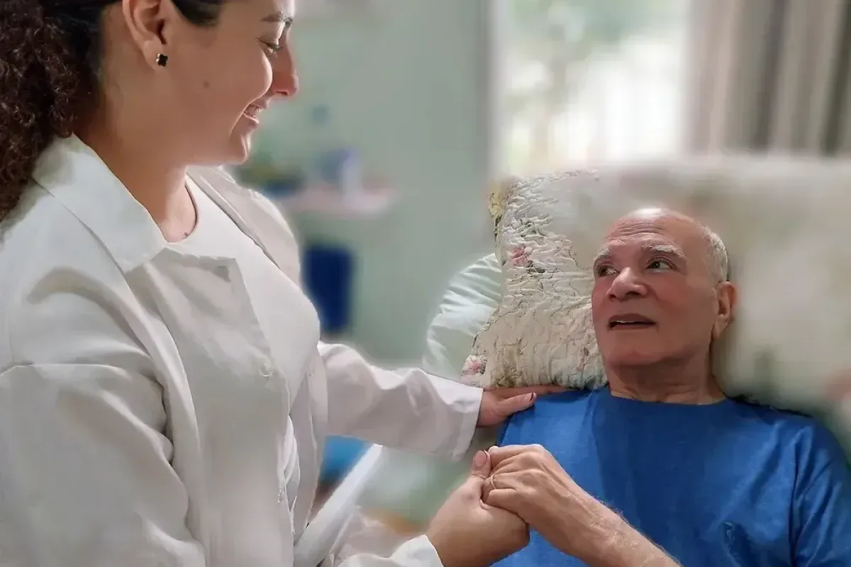 Enfermeira atendendo um paciente idoso acamado no quarto de casa